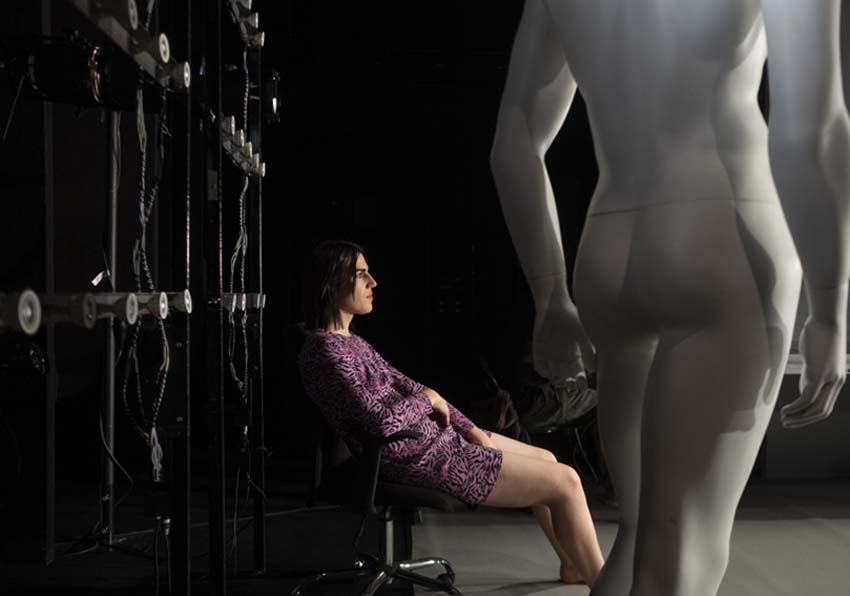 Una chica sentada junto a un maniquí